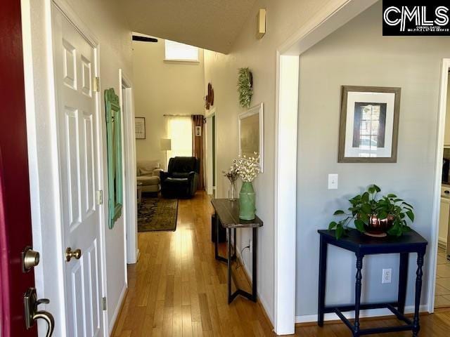 hall featuring wood finished floors and baseboards