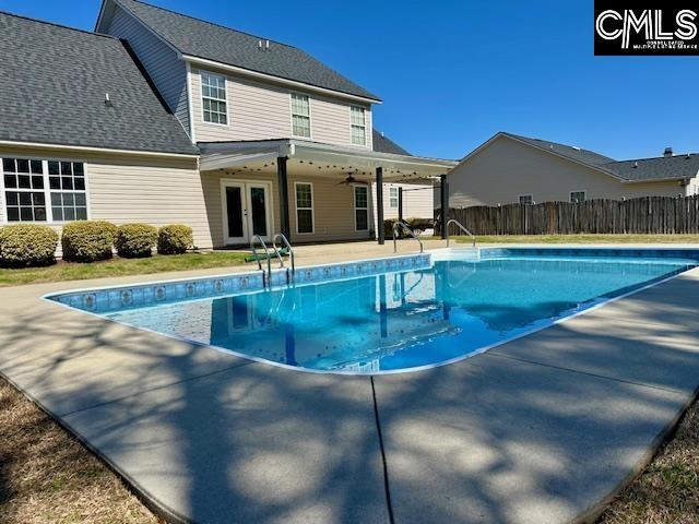 view of pool with a fenced in pool, ceiling fan, fence, french doors, and a patio