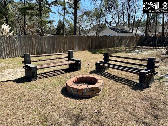 view of yard with an outdoor fire pit and fence