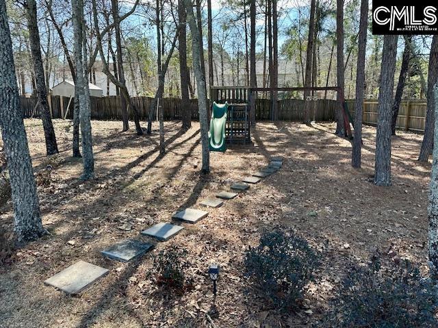 view of yard with playground community and fence