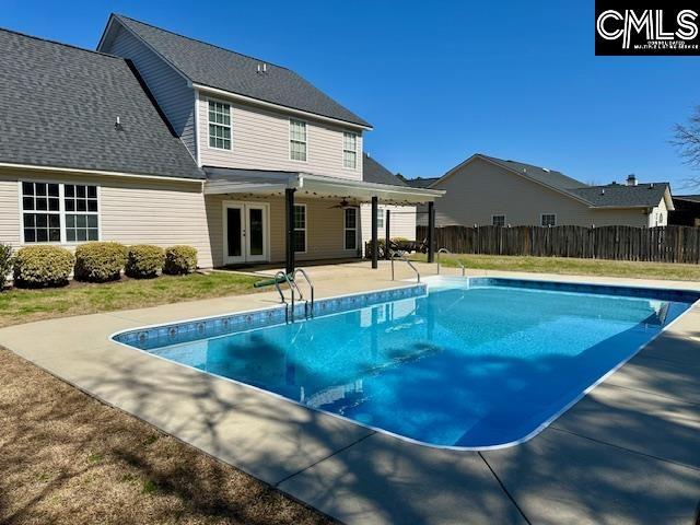 view of swimming pool with a patio, fence, french doors, a fenced in pool, and ceiling fan