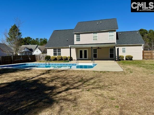 back of property with a patio, a fenced in pool, a fenced backyard, french doors, and a lawn