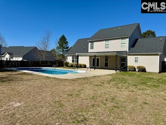 back of house with a fenced in pool, a patio, a lawn, and fence