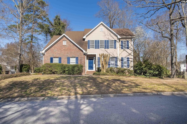 view of front of property featuring a front lawn and brick siding