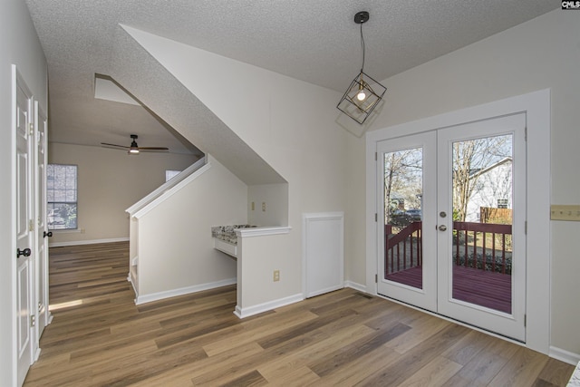 doorway featuring wood finished floors, french doors, baseboards, and a textured ceiling