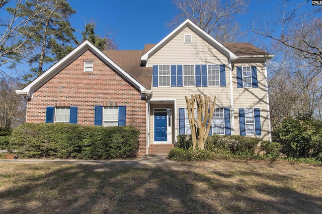 view of front facade with a front yard and brick siding