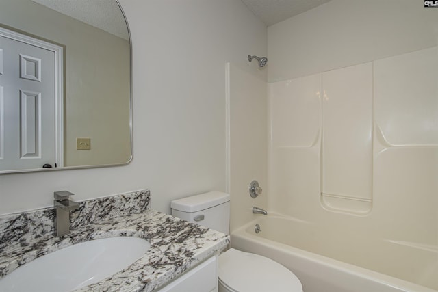 full bath featuring vanity, toilet, washtub / shower combination, and a textured ceiling