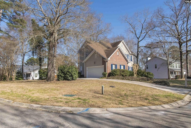 traditional home featuring brick siding, a garage, driveway, and a front lawn