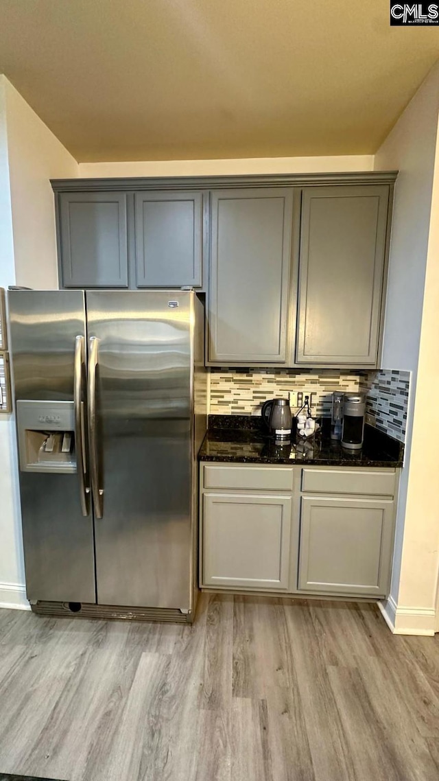 kitchen with light wood-style floors, tasteful backsplash, stainless steel fridge with ice dispenser, and gray cabinets