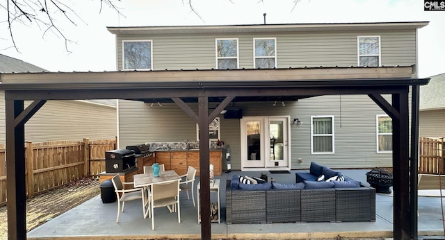 rear view of property with outdoor dining space, an outdoor living space, a patio area, and fence