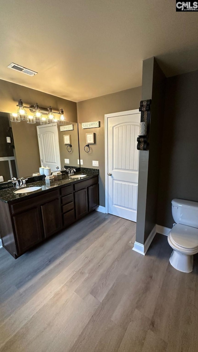 full bath featuring a sink, visible vents, toilet, and wood finished floors