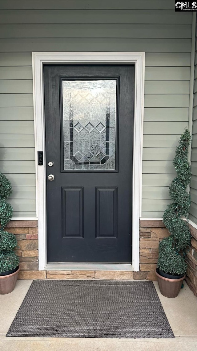 doorway to property with stone siding