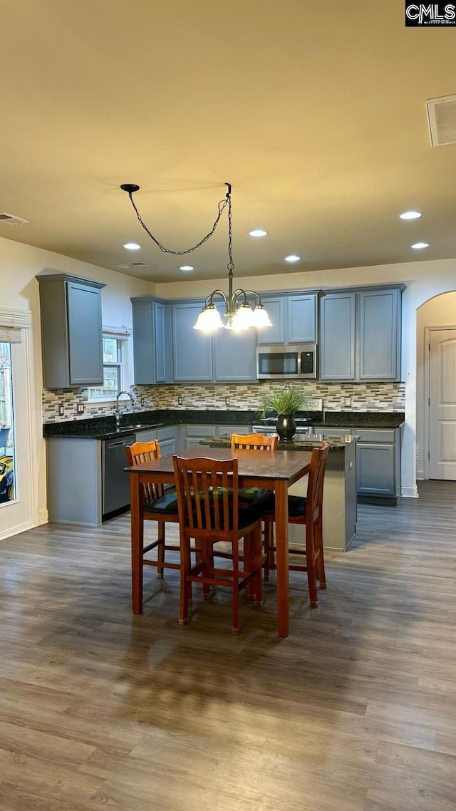 dining space with visible vents, dark wood-type flooring, and an inviting chandelier