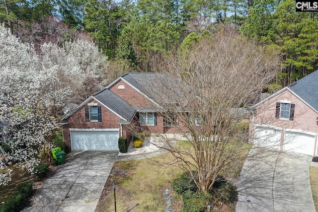 view of front facade with brick siding, driveway, and a garage