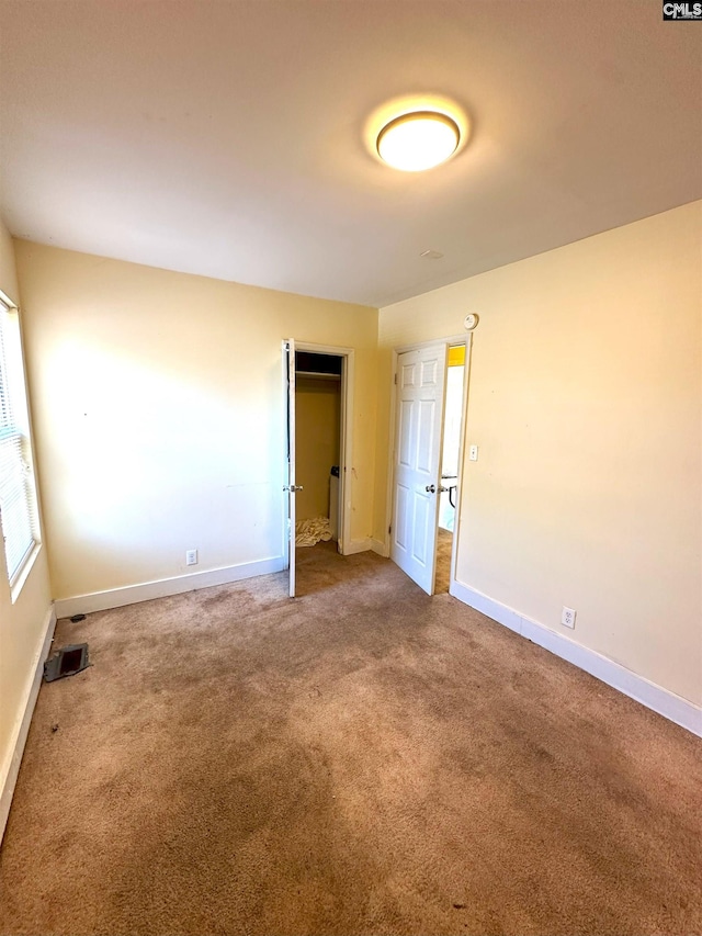 unfurnished bedroom with visible vents, carpet, baseboards, and a closet