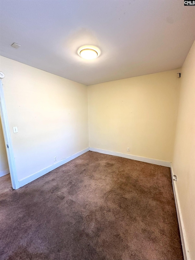 carpeted spare room featuring baseboards