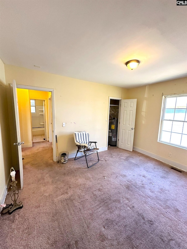 interior space featuring visible vents, baseboards, and water heater