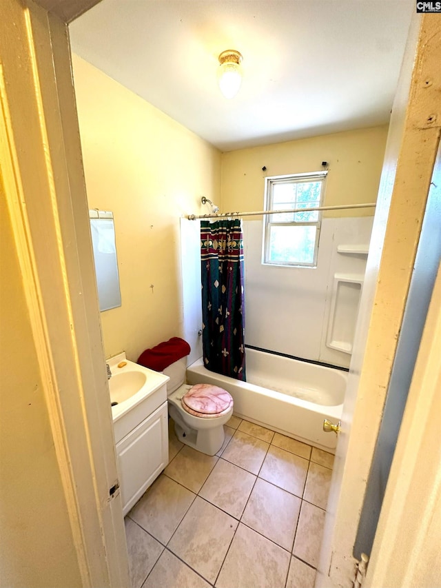 full bath featuring tile patterned floors, toilet, vanity, and shower / bath combo with shower curtain