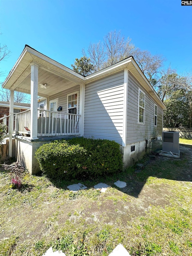 view of side of home featuring a porch and central air condition unit