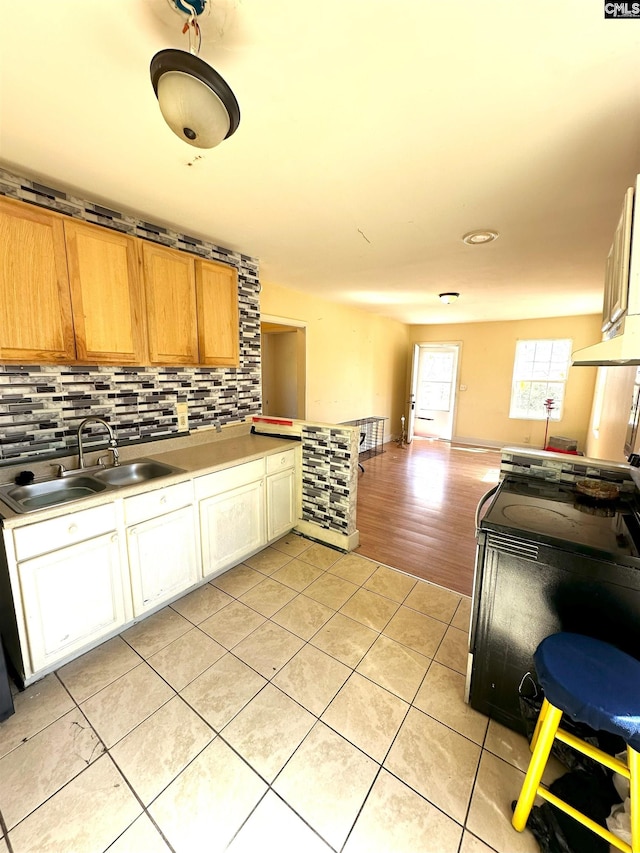 kitchen with decorative backsplash, light tile patterned flooring, open floor plan, and a sink