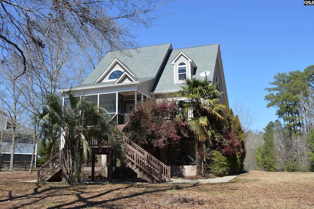 view of front facade with stairway and a sunroom