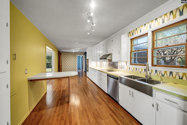 kitchen with stainless steel dishwasher, white cabinets, wood-type flooring, black electric cooktop, and a sink