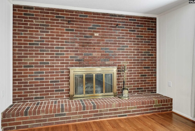 room details featuring ornamental molding, a fireplace, and wood finished floors