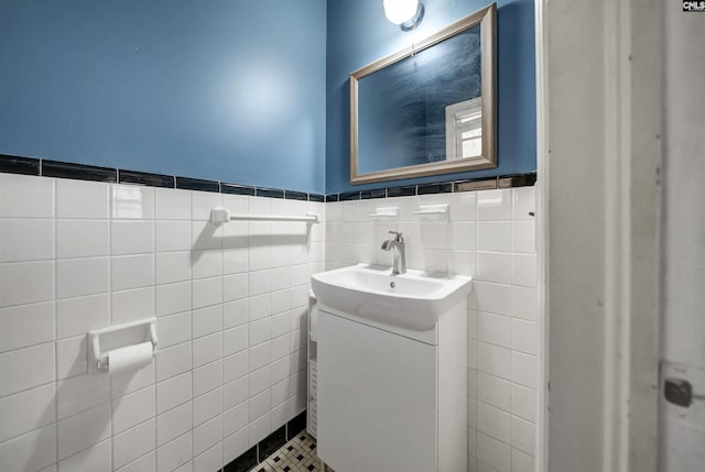 bathroom with a wainscoted wall, vanity, and tile walls