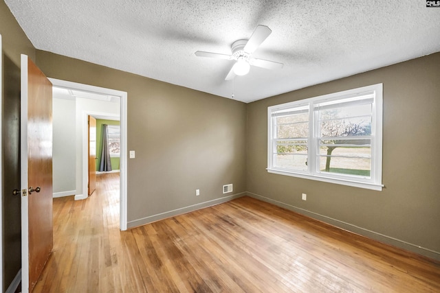 empty room with visible vents, baseboards, light wood-style floors, and ceiling fan