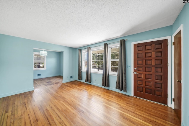 foyer entrance featuring plenty of natural light, baseboards, and light wood finished floors