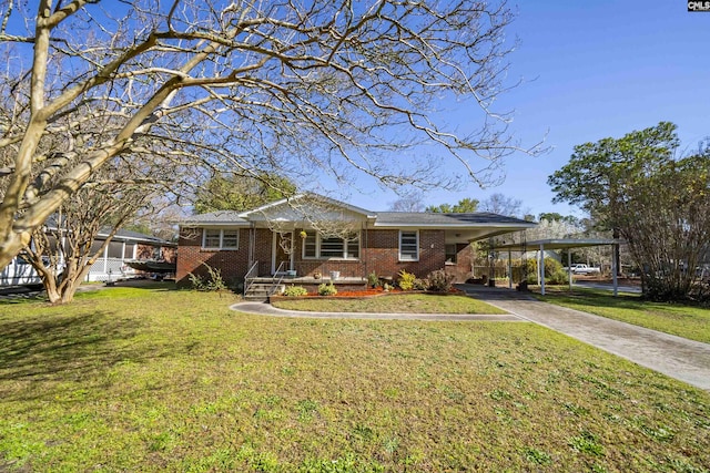 ranch-style home with brick siding, driveway, a front yard, and a carport