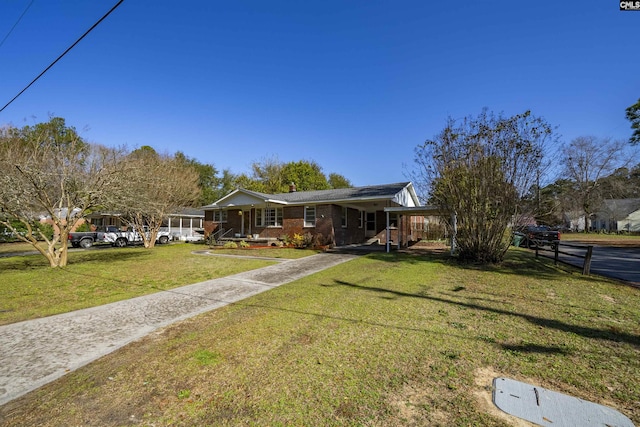 ranch-style house with a front yard and brick siding