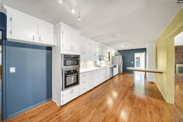 kitchen featuring visible vents, light wood-style flooring, white cabinetry, appliances with stainless steel finishes, and light countertops