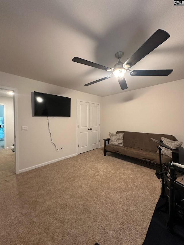 living area with carpet flooring, a ceiling fan, and baseboards