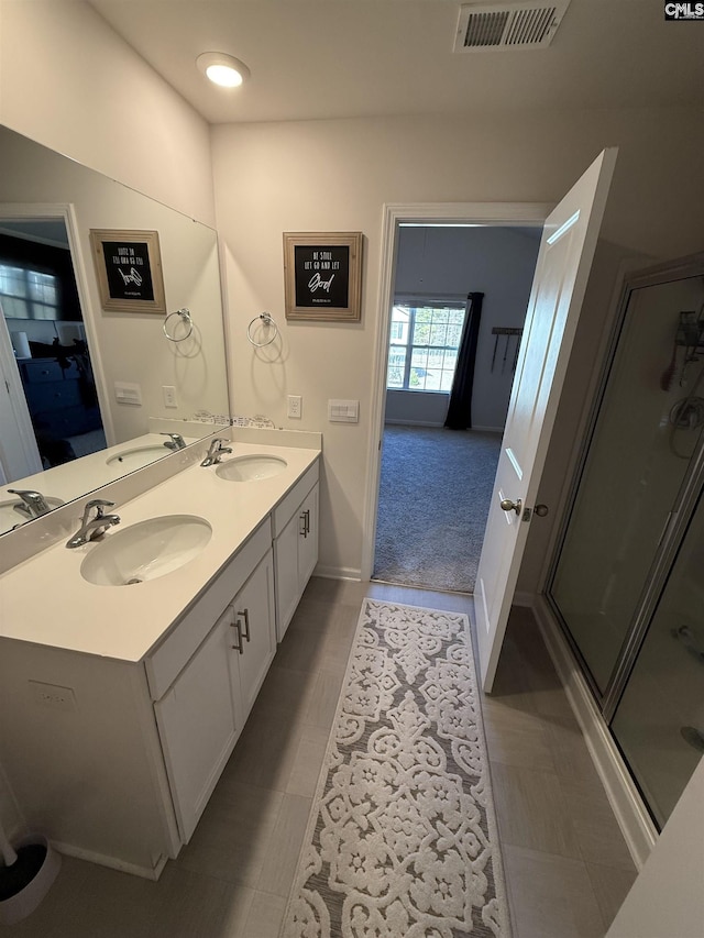 ensuite bathroom with visible vents, a shower stall, ensuite bath, and a sink