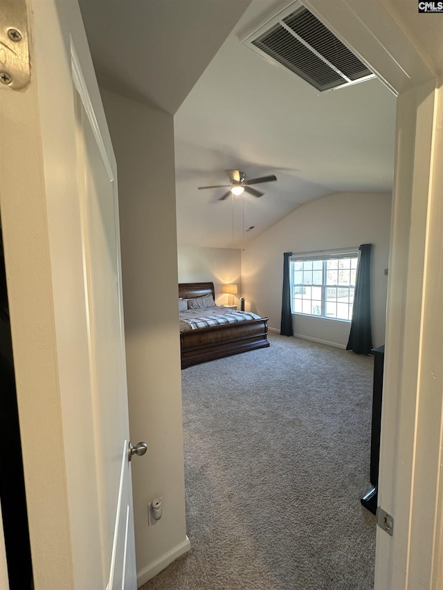 unfurnished bedroom featuring visible vents, baseboards, vaulted ceiling, carpet floors, and a ceiling fan