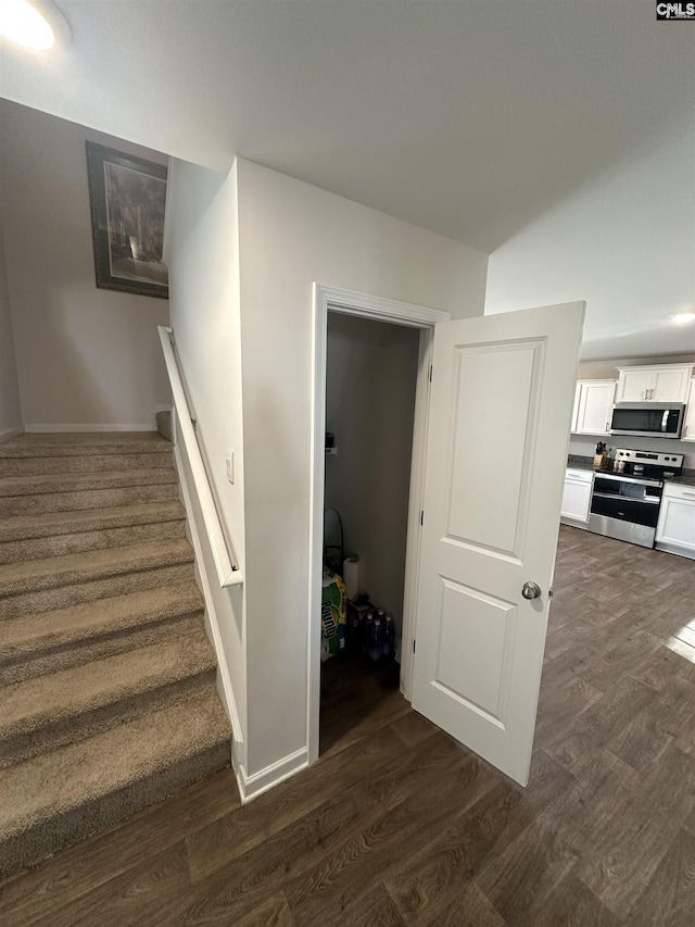 stairway featuring baseboards and wood finished floors