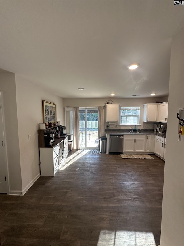 kitchen featuring dark countertops, dark wood-style flooring, white cabinetry, and stainless steel dishwasher