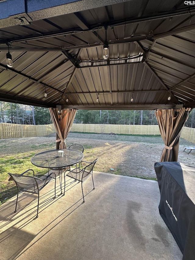 view of patio / terrace with a gazebo, outdoor dining space, and fence