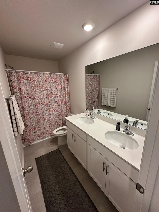 bathroom with a sink, a shower with curtain, toilet, and double vanity