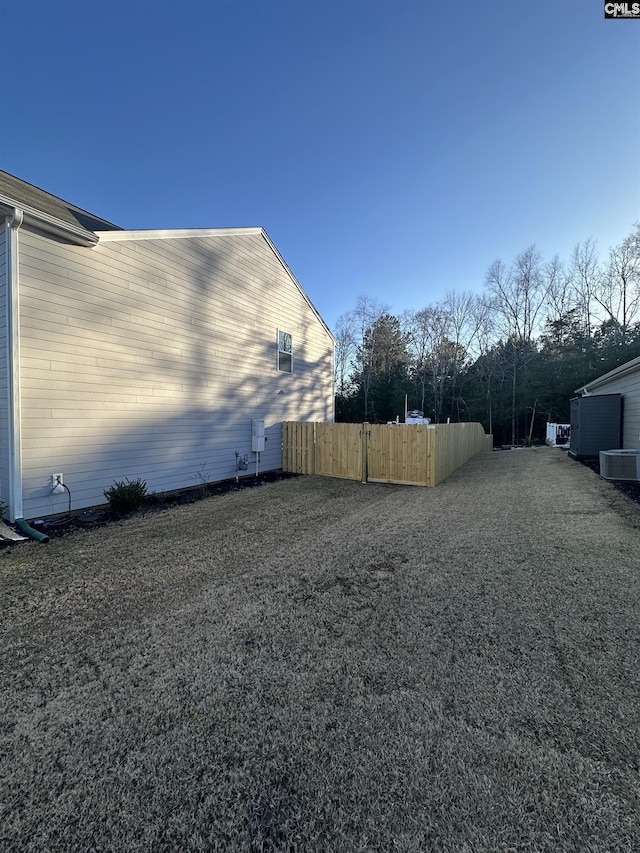 view of yard with fence and central AC