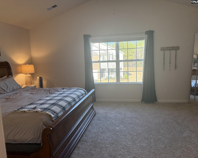 carpeted bedroom with vaulted ceiling, baseboards, and visible vents