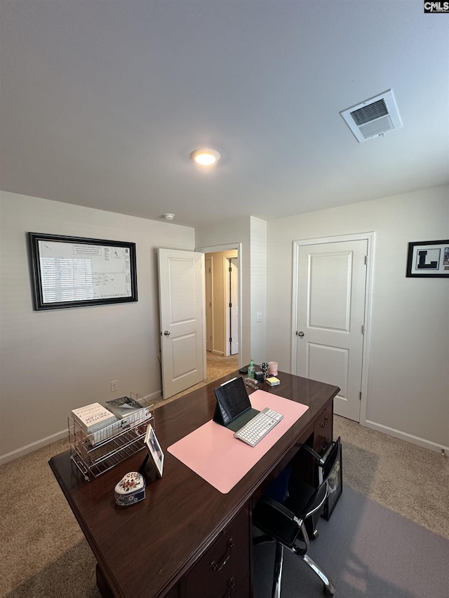 office space featuring visible vents, baseboards, and light colored carpet