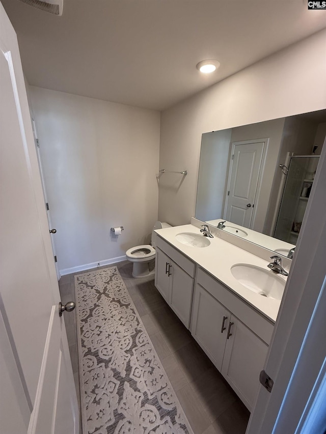 full bath with double vanity, a stall shower, toilet, and a sink