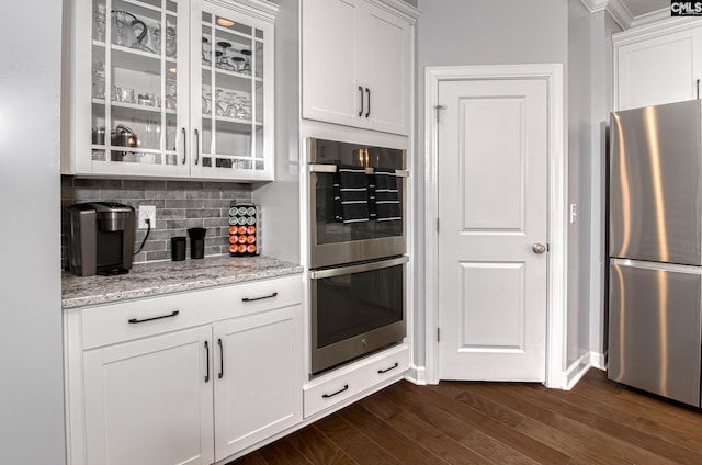 263 Compass Trl, Blythewood, SC 29016 - kitchen featuring decorative backsplash, light stone counters, dark wood-style floors, stainless steel appliances, and glass insert cabinets