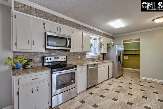 kitchen featuring a sink, backsplash, appliances with stainless steel finishes, and crown molding