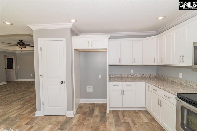 kitchen with white cabinetry, stainless steel appliances, and ornamental molding