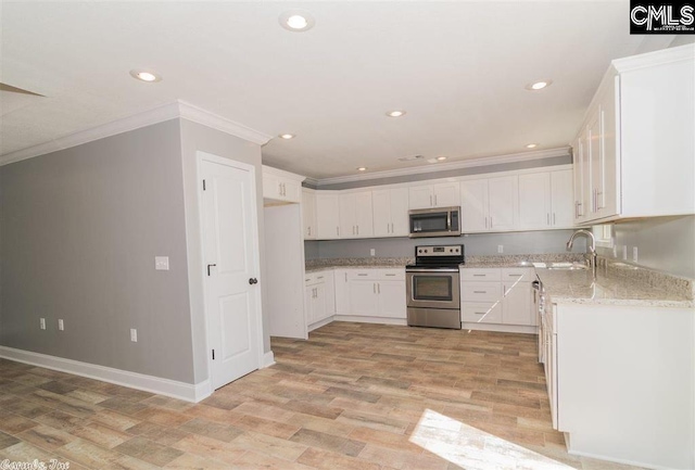 kitchen featuring crown molding, light stone counters, stainless steel appliances, white cabinetry, and a sink