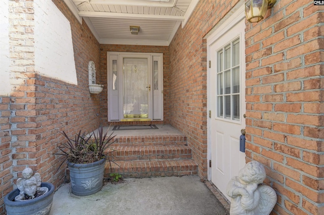 doorway to property with brick siding