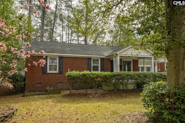 view of front of property with crawl space, brick siding, covered porch, and a front yard